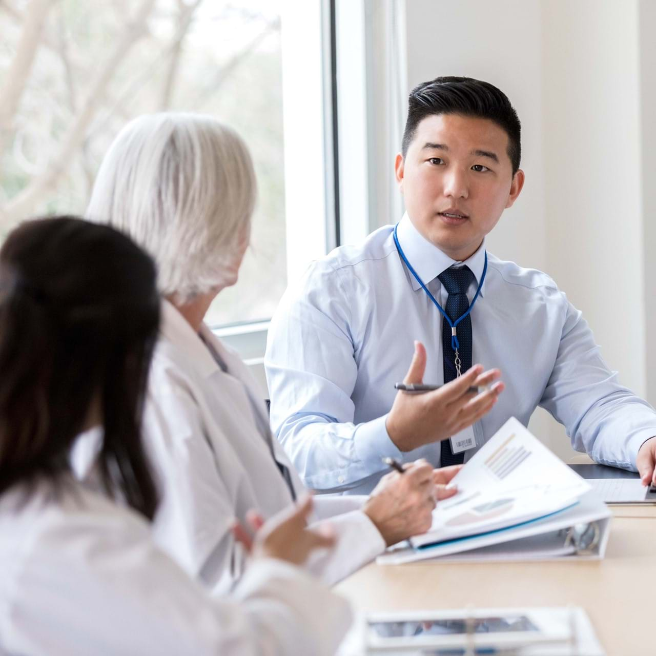 Doctor speaking to other doctors at table